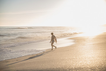 Silhouette woman walking on sunny summer ocean beach