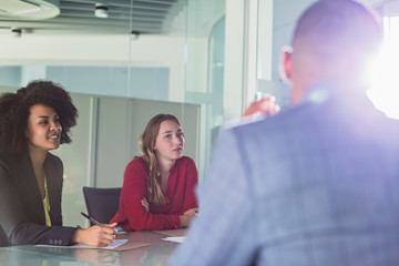 Attentive businesswomen listening in conference room meeting