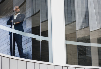 Portrait confident CEO businessman standing in office window