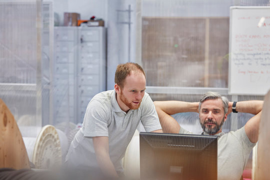 Male supervisors working at computer in factory