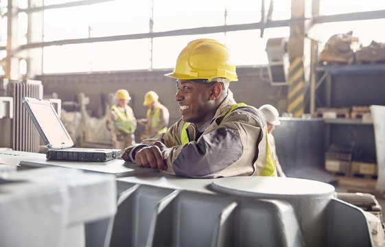 Smiling steelworker looking away in steel mill