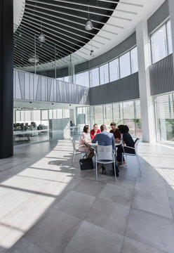 Business people meeting at table in modern office atrium