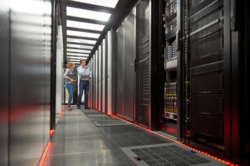 IT technicians talking at panel in server room