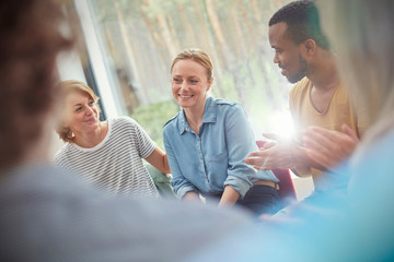 People clapping for woman in group therapy session