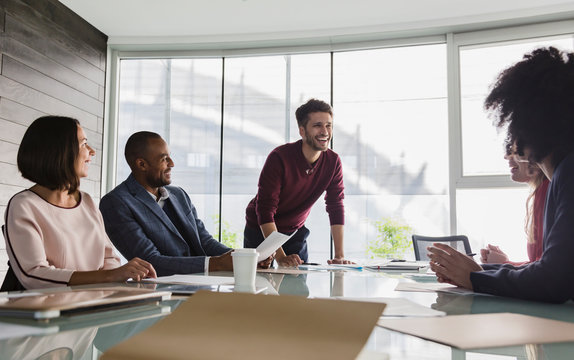 Smiling Businessman Leading Conference Room Meeting