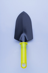 Steel garden trowel tool with yellow handle. Short shovel for garden works isolated on white, close-up.
