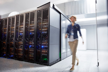 Female IT technician walking in server room