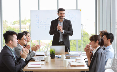 caucasian lecturer giving public presentation in meeting room and multiethnic business people are paying attention (training or seminar concept)