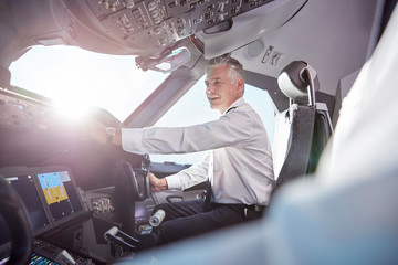 Smiling male pilot in airplane cockpit