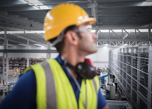 Male worker looking away on platform in factory