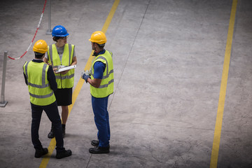 Supervisor and workers with clipboard talking in factory