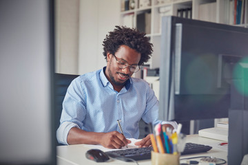 Businessman taking notes at computer in office