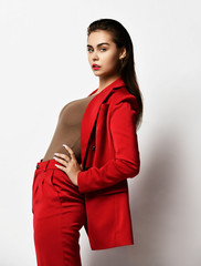 Young fashionable beautiful sexy business woman in expensive designer stylish red office suit on a white background