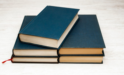 stack of blue books on wooden bookshelf