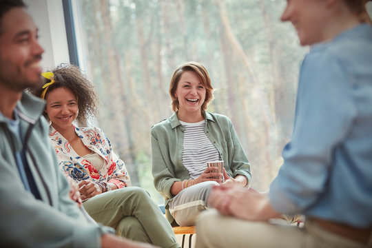 People smiling and laughing in group therapy session
