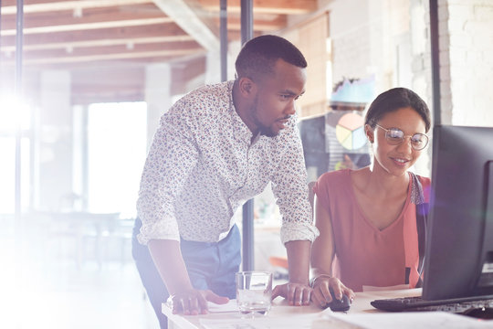 Businessman and businesswoman working at computer in office