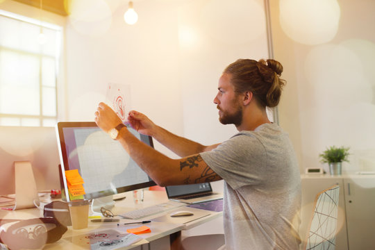 Male designer examining transparency diagram in office