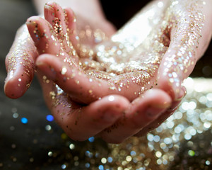 Close up hands cupping gold glitter