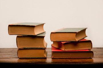 stack of old books on wooden table with white background