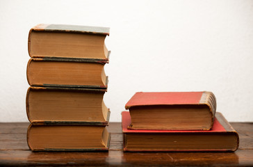 stack of old books on wooden table with light background