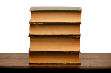 stack of old books on wooden table with white background