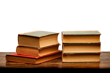 stack of old books on wooden table with white background