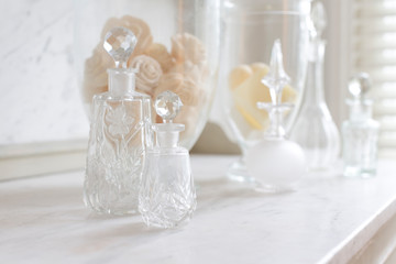 Crystal perfume bottles on white, luxury marble counter