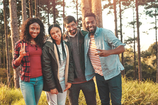 Portrait confident young friends gesturing peace sign in woods