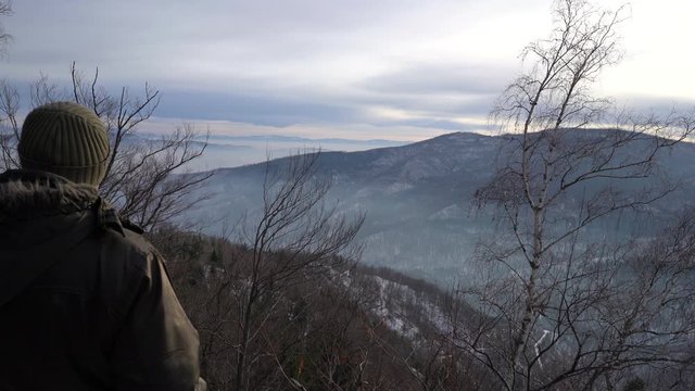 Man is watching winter landscape on mountain - (4K)