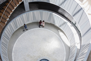 View from above business people talking in architectural, modern office atrium courtyard