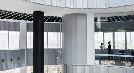 Business people talking in architectural, modern office conference room