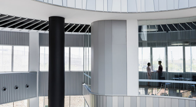 Business people talking in architectural, modern office conference room