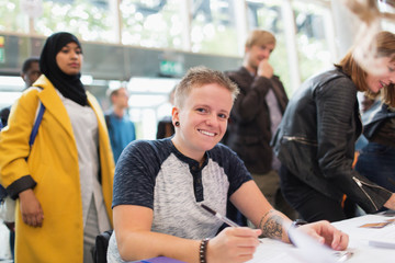 Portrait smiling woman in wheelchair checking in at conference registration table