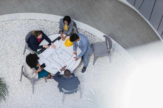 Architects reviewing blueprints, planning at table