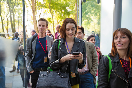 Businesswoman with smart phone arriving, entering doorway