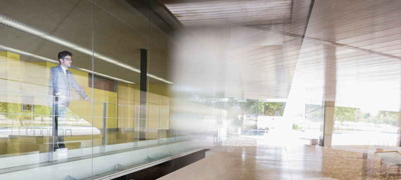 Pensive businessman standing at modern office window