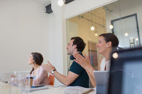 Supportive business people clapping in conference room meeting