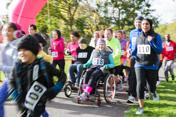 Runners and people in wheelchairs at charity run in park