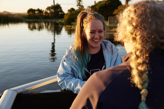 Smiling female rowers at sunny lakeside