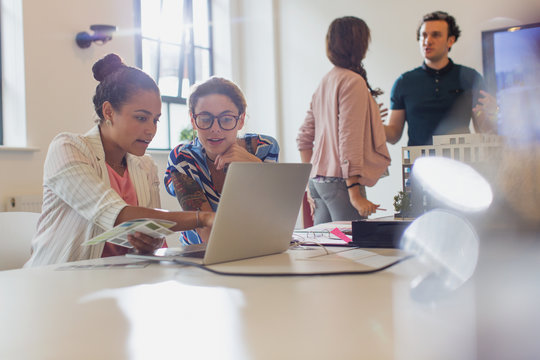 Female architects using laptop in conference room meeting