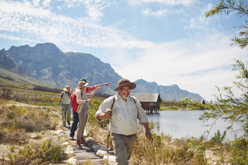 Active senior friends hiking and enjoying sunny summer lake view