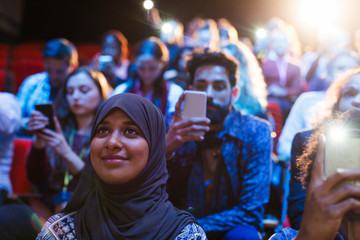 Smiling woman in hijab listening in audience