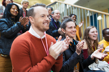Smiling conference audience clapping