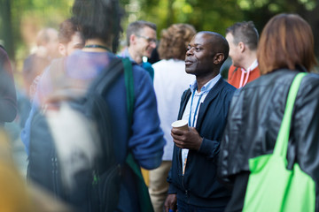 Businessman with coffee talking to colleagues at conference