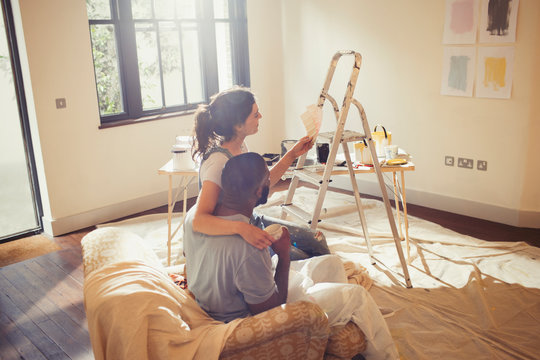 Young couple viewing paint swatches, painting living room