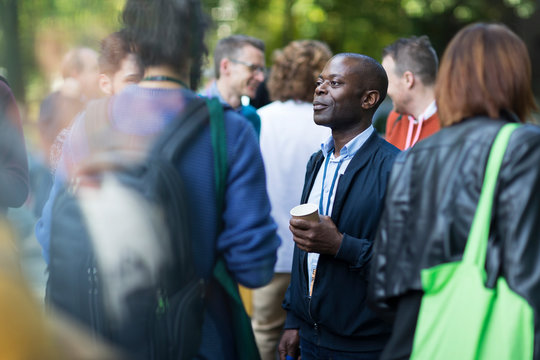 Businessman with coffee talking to colleagues at conference