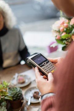 Cashier with credit card reader in cafe