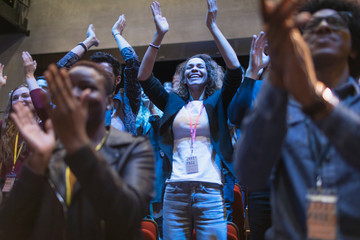 Smiling, enthusiastic woman cheering in audience