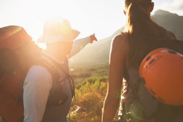 Rock climbers pointing to sunny mountain