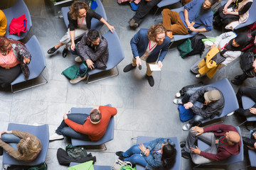 Overhead view conference audience listening to speaker with microphone